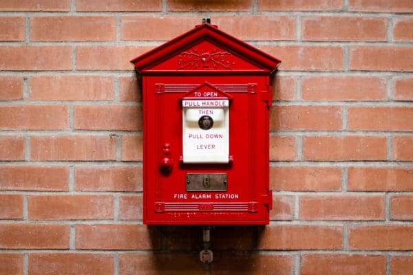A red emergency box on a brick wall