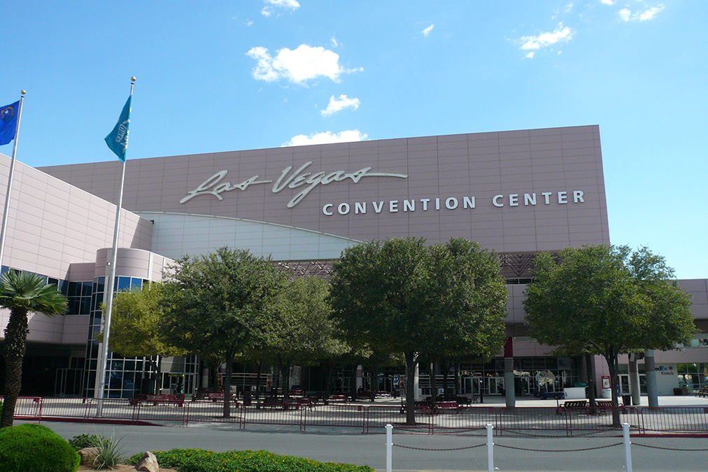 The Las Vegas Convention center, a large, angular building, on a sunny day.