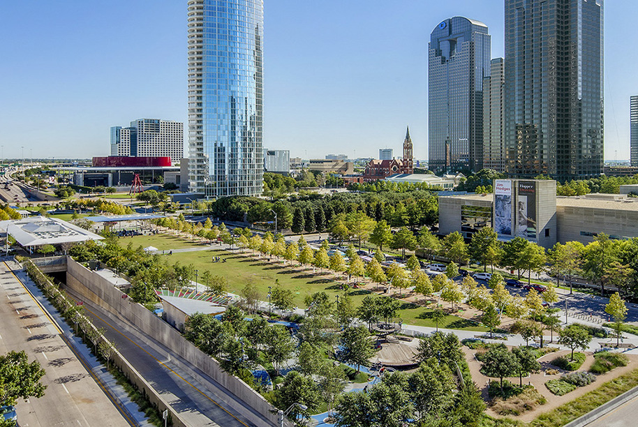 An aerial photo of downtown Dallas, Texas, showing Klyde Warren Park and the AT&T Performing Arts Center in the distance.