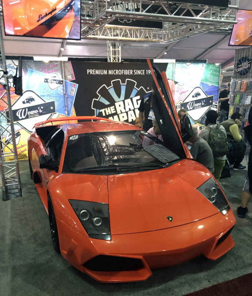 An eye-catching booth design with a show car that visitors can interact with. Using an interactive SEMA booth design like this can help attract audiences and keep their attention.