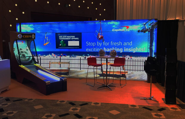 A beach themed trade show booth made by Cardinal Expo for Capital One. It includes a boardwalk theme and a skeeball game.