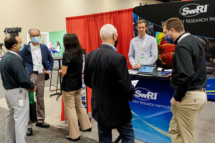 Experience Power exhibition booth 2022 Attendees at the 2022 Experience Power conference mingle among exhibition booths.