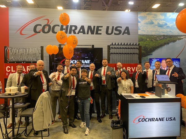 The Cochrane USE team dressed in red ties and neutral suits to match their brand colors for cohesive trade show attire.