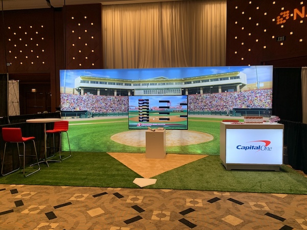 A backlit trade show display in a convention center designed by Cardinal Expo