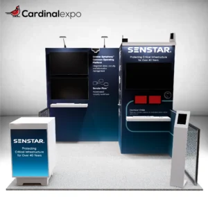 Frontal perspective of a 10x10 exhibit featuring an L-shaped backwall with monitors, chainlink fences, kiosk, and podium.