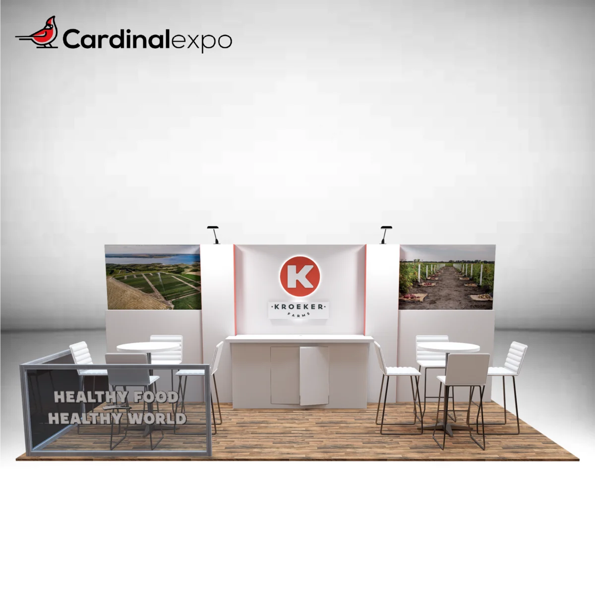 Front view of a 10x20 trade show booth rental featuring a 3D backlit logo sign, central reception counter, farm landscape graphics, dual bistro sets, and glass railing partition.