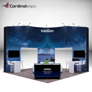 Front-left angle of a 20x20 trade show booth rental featuring a 3D backlit logo sign on a curved header wall, backlit reception desk, twin TV displays, and high-top seating stations.