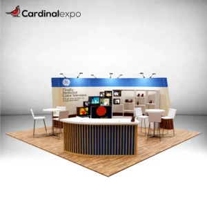 Front-left angle of a 20x20 trade show display rental showcasing a wood-slatted curved reception desk, vintage television display wall, and high-top seating.