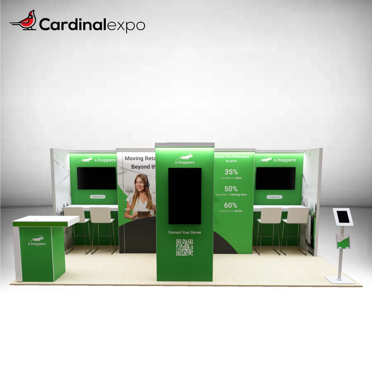 Front view of a 10x20 trade show booth rental featuring a green central media tower with a TV screen, dual demo counters with monitors, a green reception desk, and a freestanding tablet kiosk.